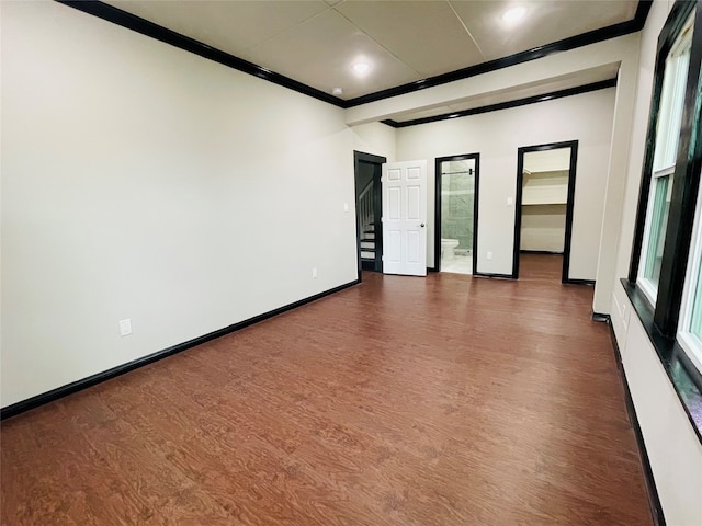 spare room with dark hardwood / wood-style flooring and crown molding