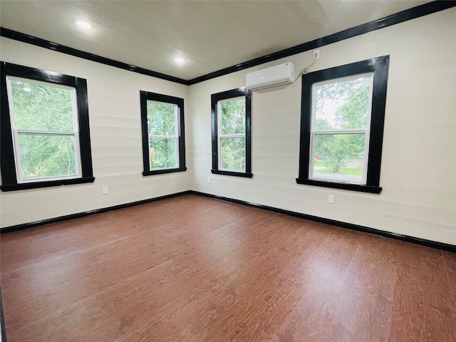 unfurnished room with wood-type flooring, an AC wall unit, and crown molding