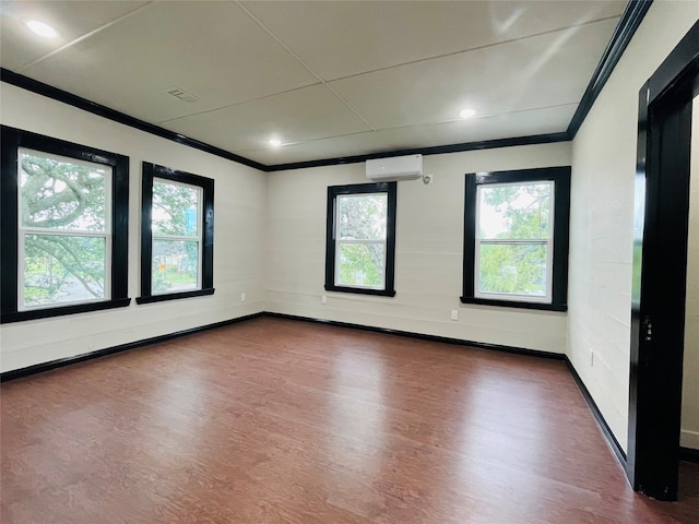 empty room with dark hardwood / wood-style flooring, ornamental molding, and a wall mounted AC