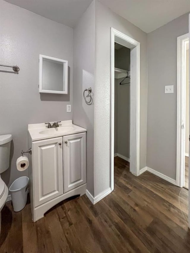 bathroom with vanity, toilet, and wood-type flooring