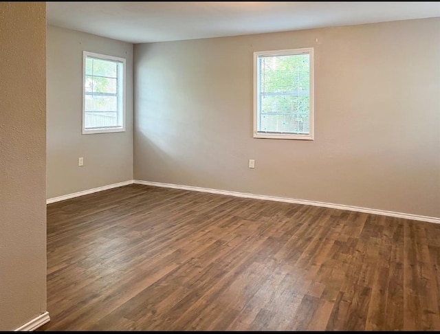 empty room with dark hardwood / wood-style flooring