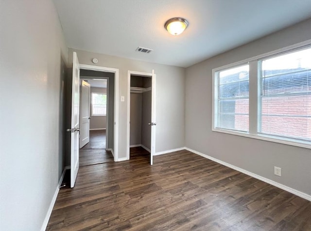 unfurnished bedroom featuring a closet and dark hardwood / wood-style floors