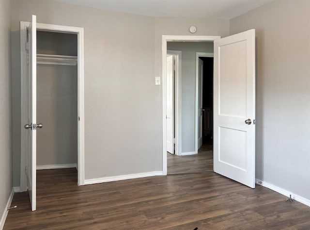 unfurnished bedroom featuring dark wood-type flooring and a closet