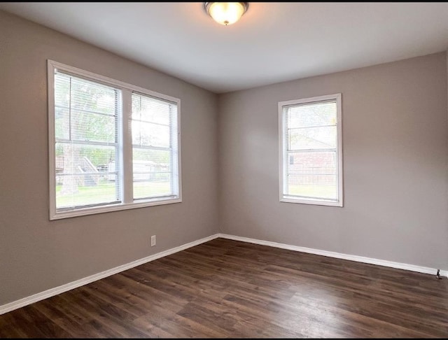 unfurnished room with a healthy amount of sunlight and dark wood-type flooring