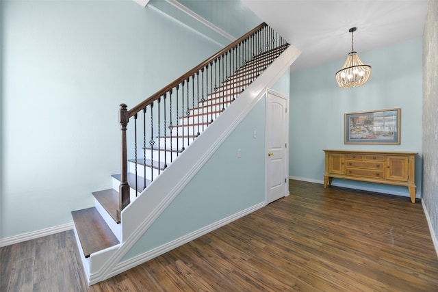 stairs featuring wood-type flooring and a chandelier