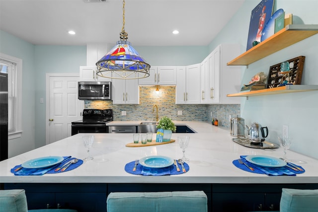 kitchen with a kitchen bar, black range with electric stovetop, kitchen peninsula, and decorative light fixtures