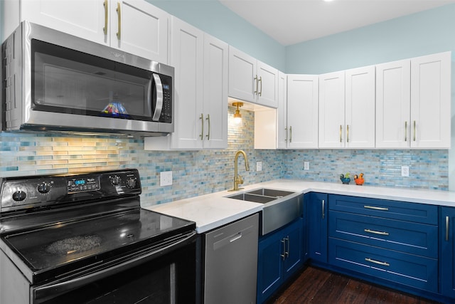 kitchen with stainless steel appliances, decorative backsplash, and blue cabinetry