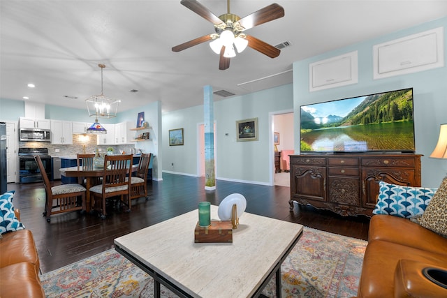 living room with ceiling fan with notable chandelier and dark wood-type flooring