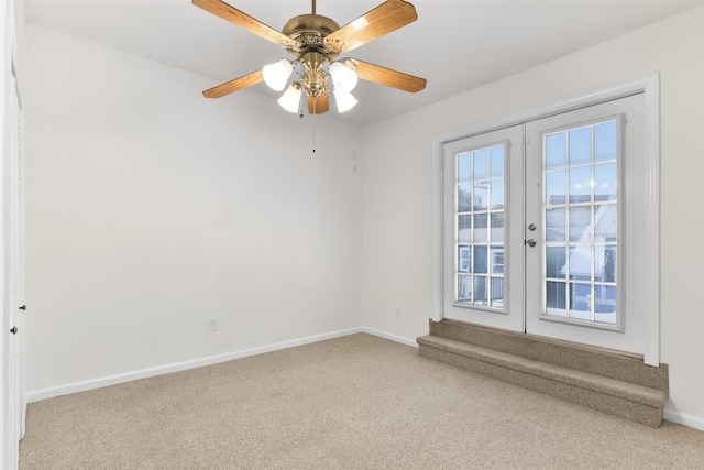 carpeted spare room featuring french doors, plenty of natural light, and ceiling fan