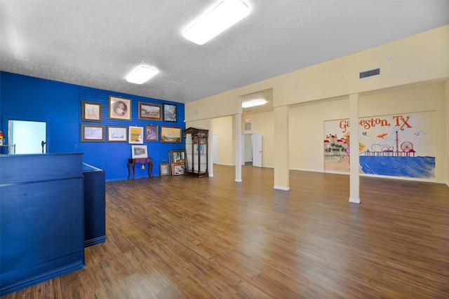 interior space with a textured ceiling and dark hardwood / wood-style flooring