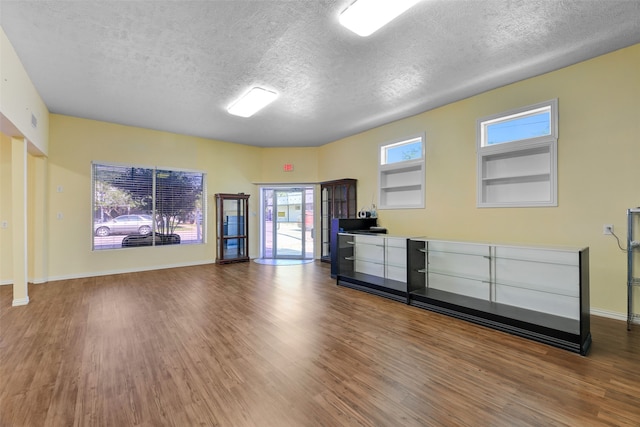 unfurnished living room featuring a textured ceiling and hardwood / wood-style flooring