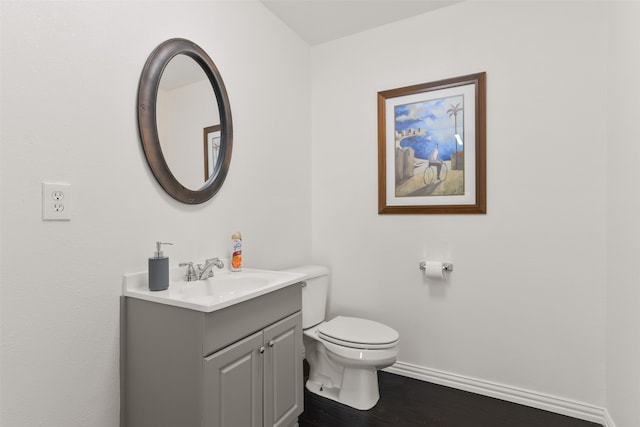 bathroom featuring wood-type flooring, toilet, and vanity