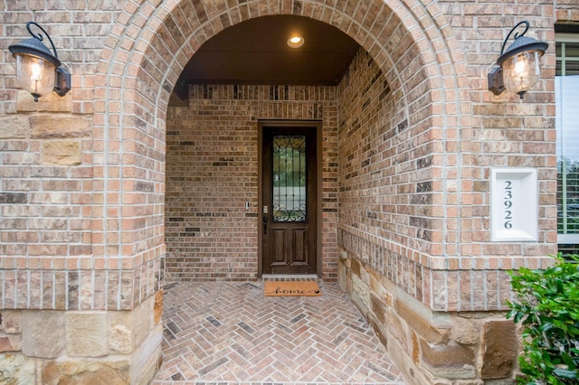 doorway to property featuring brick siding