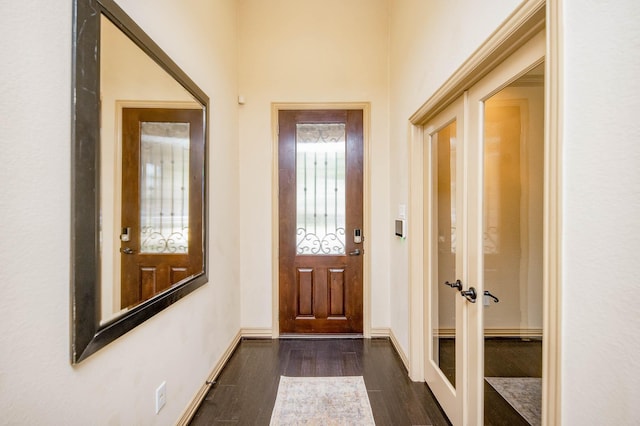 foyer entrance with dark wood-style flooring, baseboards, and french doors