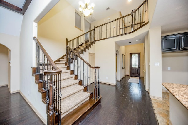 interior space featuring arched walkways, wood finished floors, and baseboards