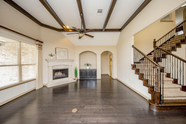 unfurnished living room featuring visible vents, a fireplace with raised hearth, ceiling fan, wood finished floors, and baseboards