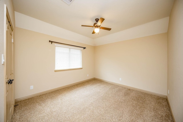 carpeted spare room featuring a ceiling fan and baseboards