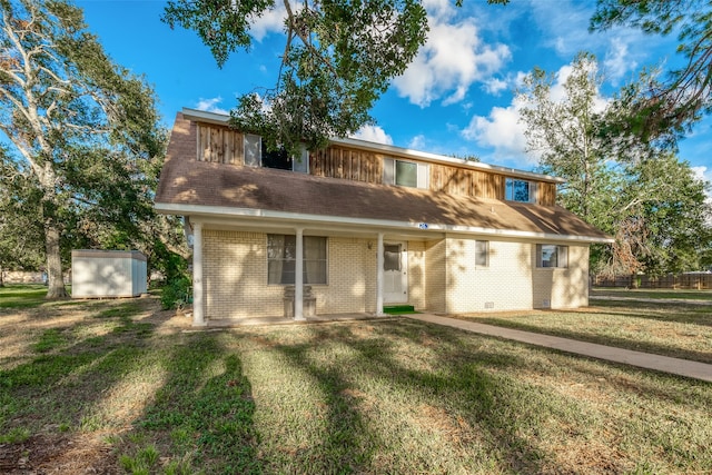 view of front of house featuring a storage unit and a front lawn