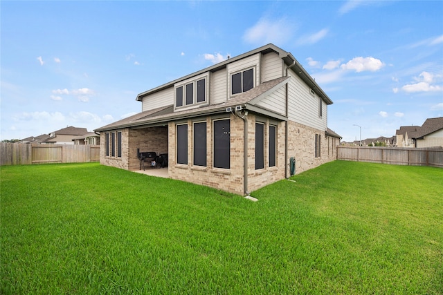 back of house with a patio area and a yard