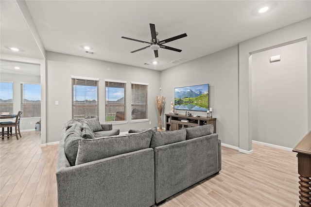 living room with light hardwood / wood-style floors and ceiling fan