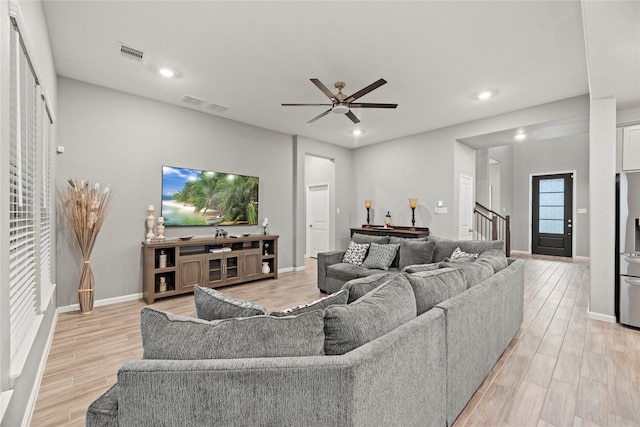 living room with light hardwood / wood-style floors and ceiling fan