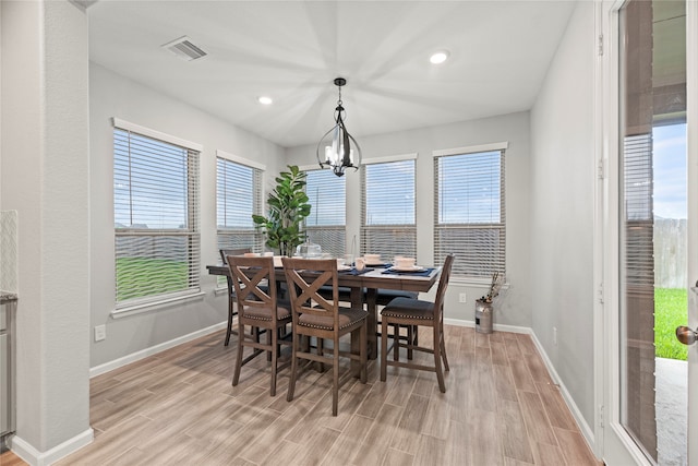 dining room featuring a chandelier, light hardwood / wood-style floors, and a healthy amount of sunlight