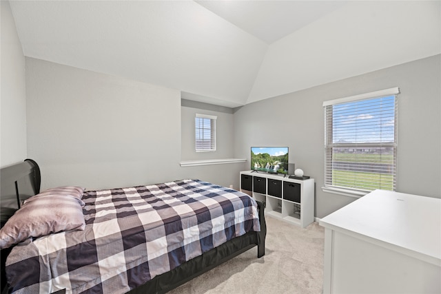 carpeted bedroom featuring multiple windows and lofted ceiling