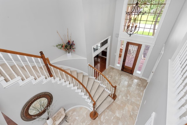 entrance foyer with a chandelier and a towering ceiling