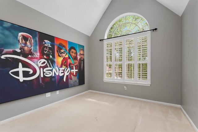 carpeted empty room with a wealth of natural light and vaulted ceiling