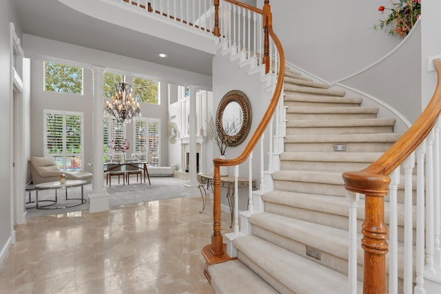 stairway featuring a chandelier and a towering ceiling