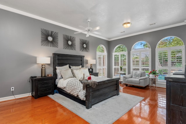 bedroom with multiple windows, ceiling fan, hardwood / wood-style flooring, and crown molding