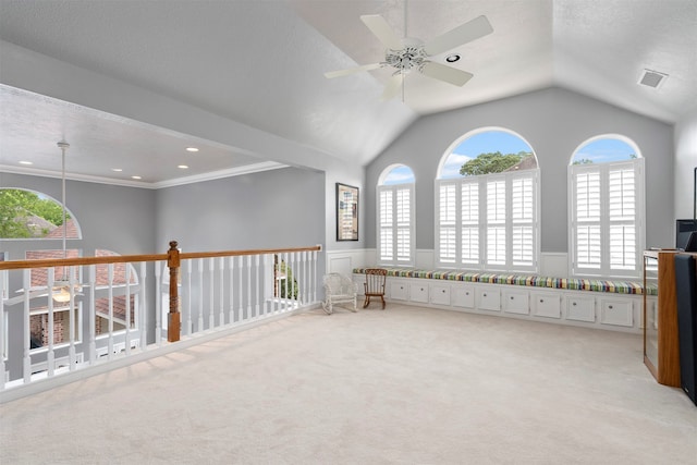 interior space with lofted ceiling, ceiling fan, light carpet, and crown molding