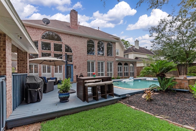 rear view of house featuring a pool side deck