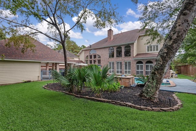 back of house featuring a jacuzzi, a yard, and a patio