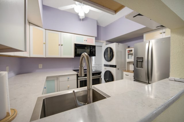 kitchen featuring stacked washer and clothes dryer, ceiling fan, appliances with stainless steel finishes, and white cabinetry