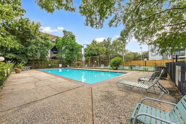 community pool featuring a patio and fence