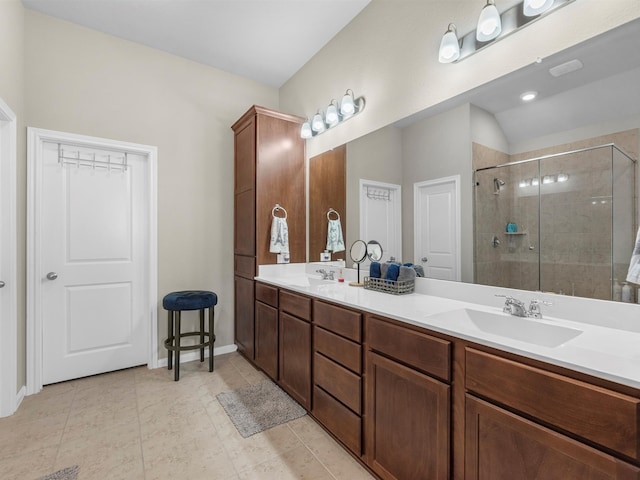 bathroom featuring vanity, vaulted ceiling, tile patterned floors, and walk in shower