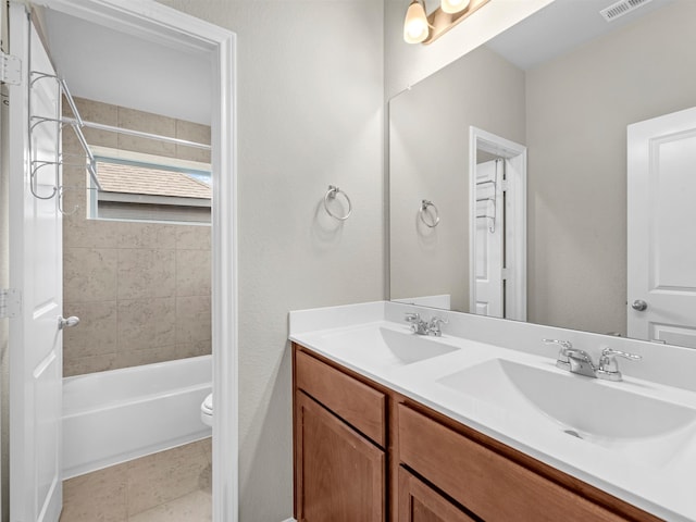 full bathroom featuring vanity, toilet, tiled shower / bath combo, and tile patterned floors