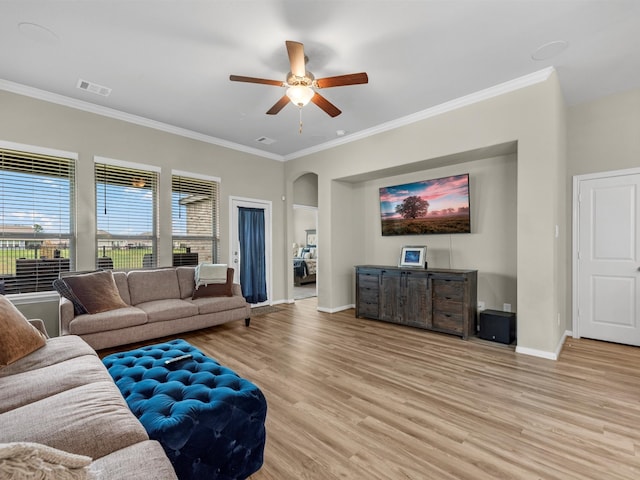 living room with crown molding, ceiling fan, and light wood-type flooring