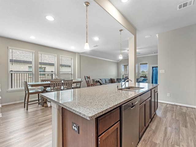 kitchen featuring light hardwood / wood-style flooring, pendant lighting, sink, and stainless steel dishwasher