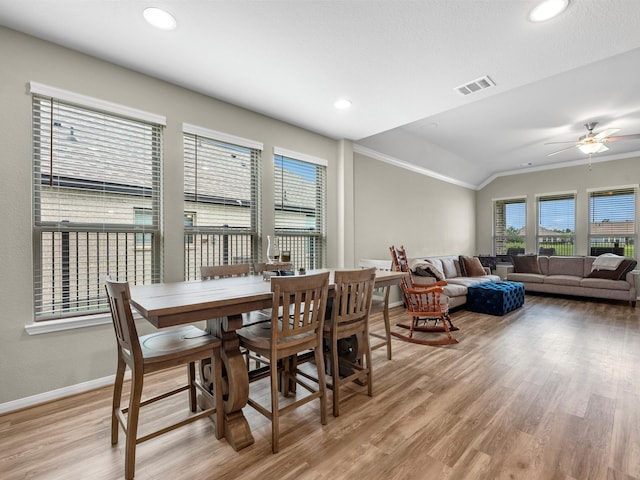 dining space featuring lofted ceiling, ceiling fan, crown molding, and light hardwood / wood-style flooring