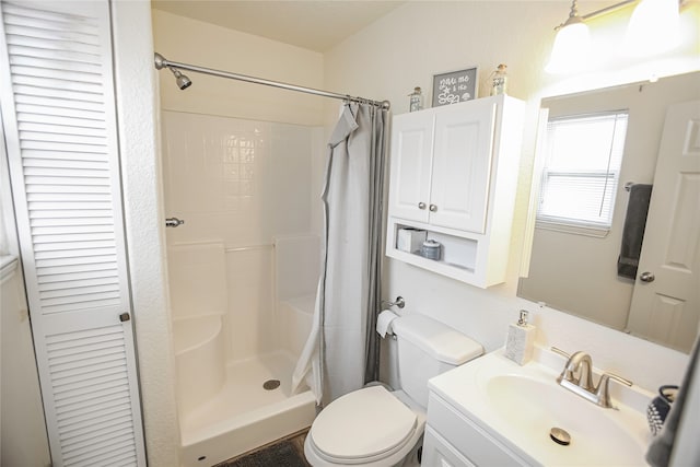 bathroom featuring walk in shower, vanity, and toilet