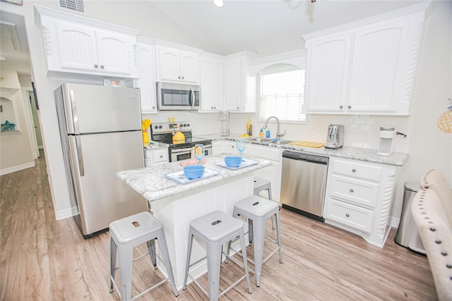 kitchen with appliances with stainless steel finishes, sink, light hardwood / wood-style floors, and white cabinets