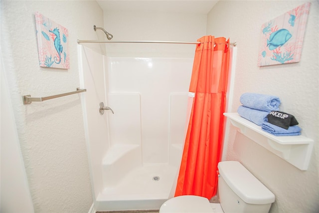 bathroom featuring toilet and a shower with shower curtain