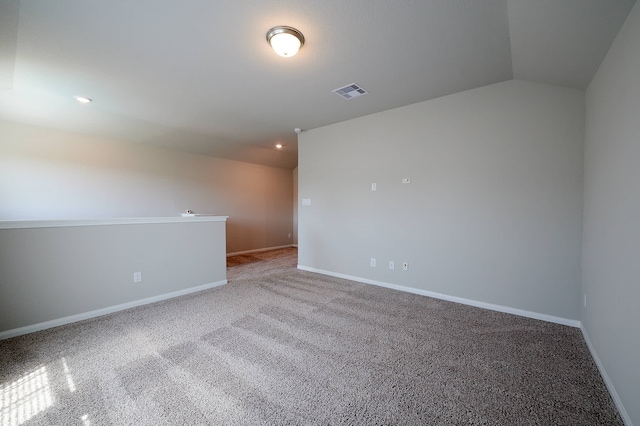 unfurnished room featuring lofted ceiling and carpet flooring