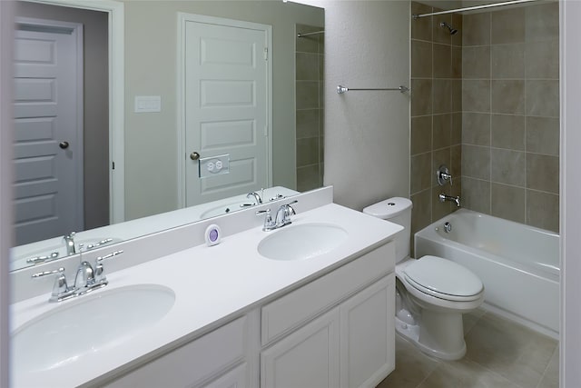 full bathroom with tile patterned floors, tiled shower / bath, vanity, and toilet