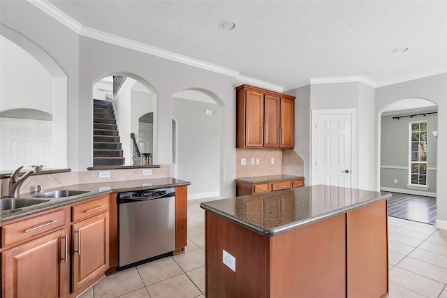 kitchen with backsplash, dishwasher, dark stone countertops, a kitchen island, and ornamental molding