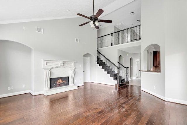 unfurnished living room with ceiling fan, dark hardwood / wood-style floors, and high vaulted ceiling