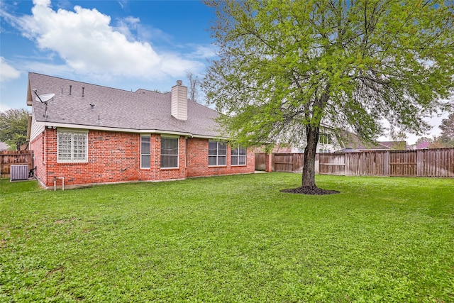 back of property with a lawn and central AC unit