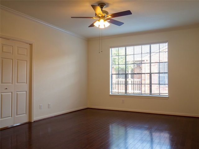 empty room featuring dark wood-type flooring, ceiling fan, and crown molding